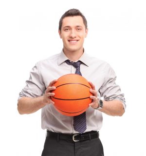 Young businessman holding a basketball and looking at the camera isolated on white background